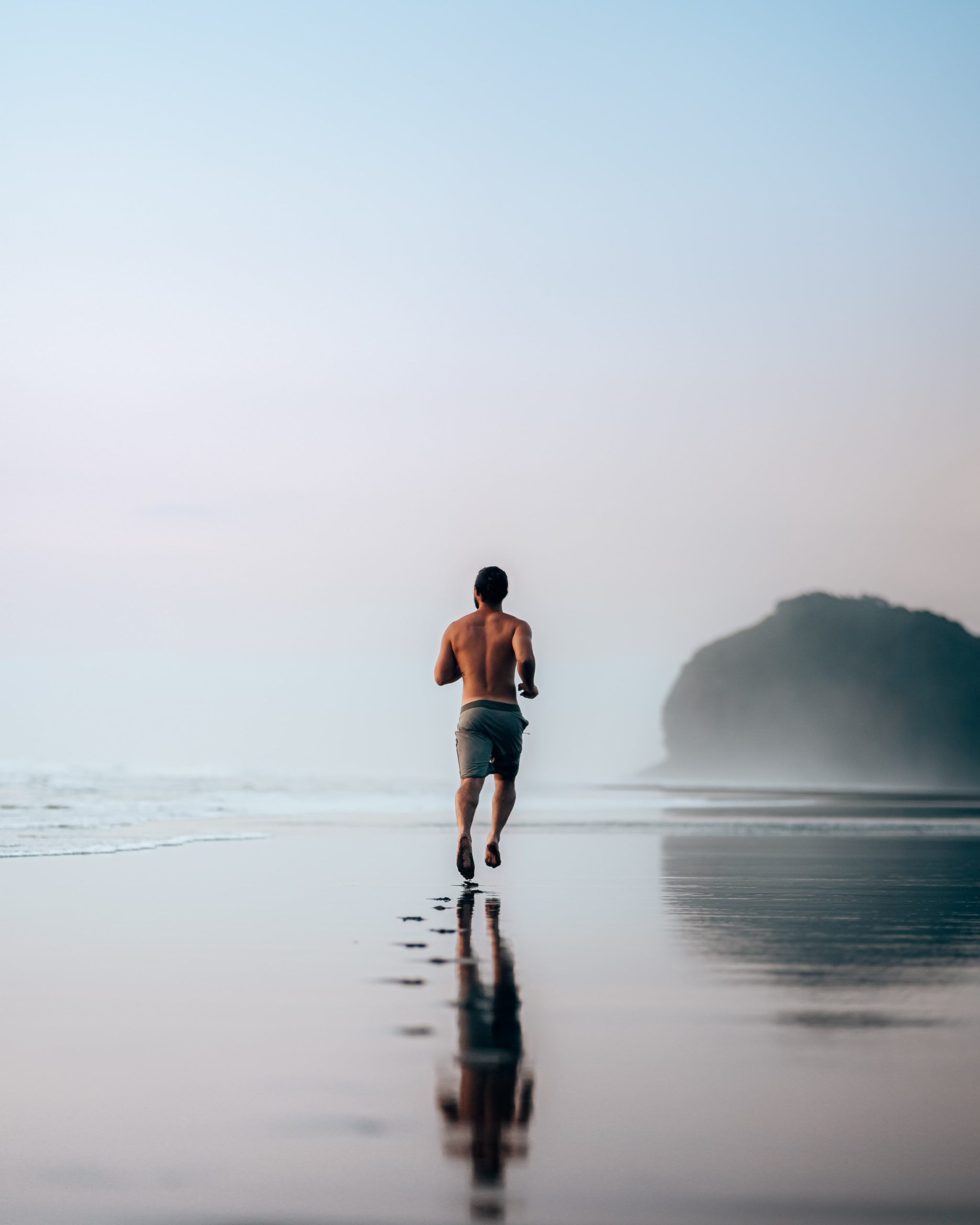 Male running on the on the sand by the ocean